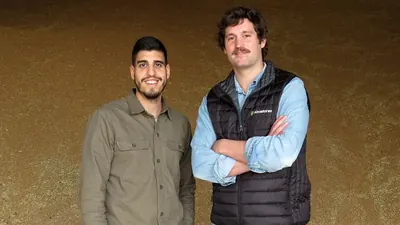 Dos miembros del equipo de Abastores ante un montón de grano