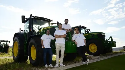 Miembros del equipo de Abastores junto a un tractor en el campo