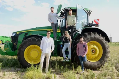 Miembros del equipo de Abastores junto a un tractor en el campo